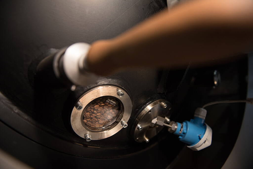 Artisan roasting machine filled with coffee beans.