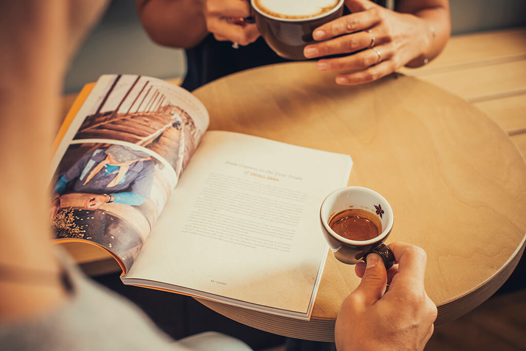 Man holding an espresso Coffee Island cup. 