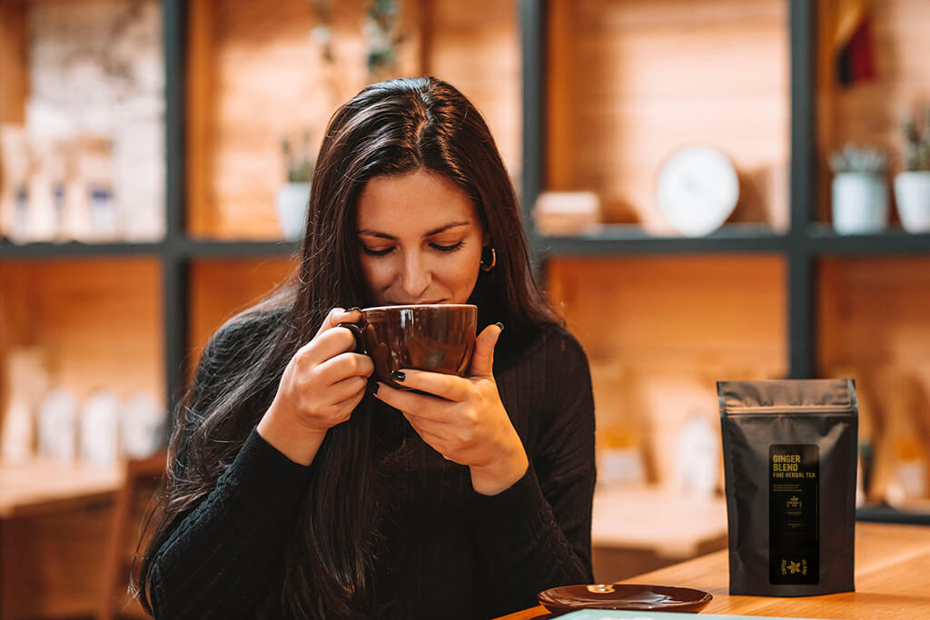 Woman drinking Coffee Island's Ginger Blend Tea