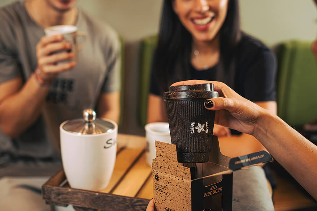 A woman unpacking in front of her friends coffee island's Kaffee Form.