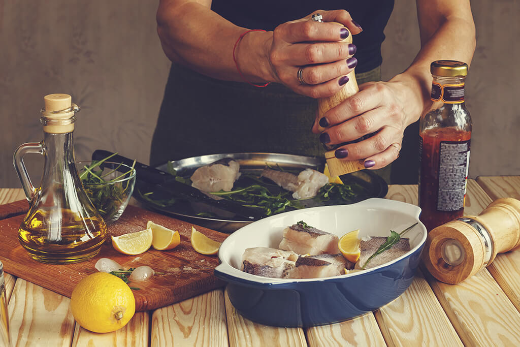 A woman preparing a fish for her lunch.