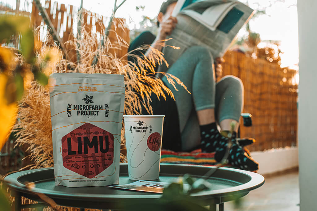 A woman enjoying her Coffee Island Ethiopia Limu Microfarm at her balcony.