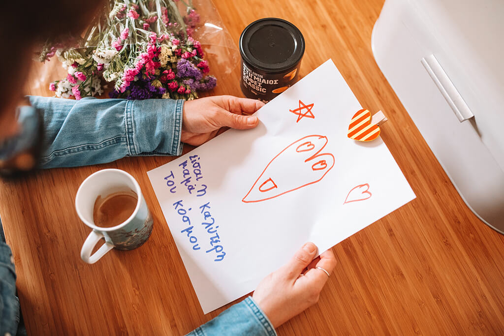 A mother reading her child's wishes to her on Mother's Day while drinking Coffee Island's instant coffee.