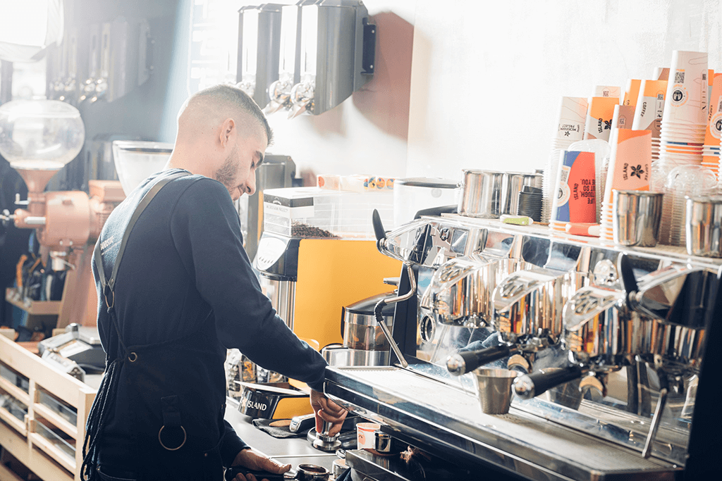 A Coffee Island's barista making coffee. 