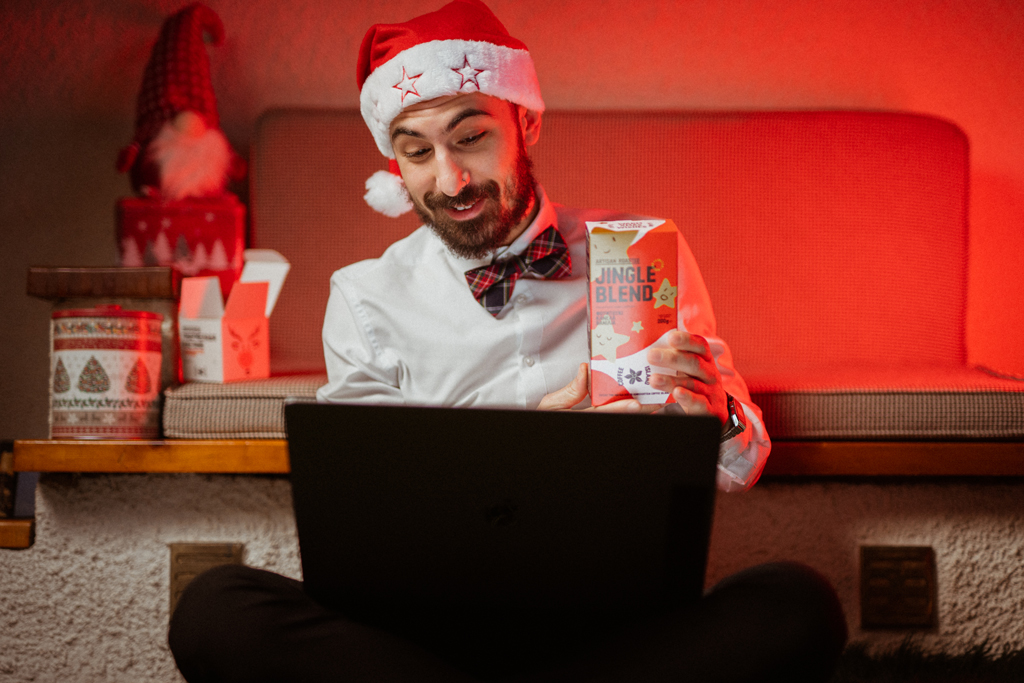 A man showing to his friends through his laptop Coffee Island's jingle blend.