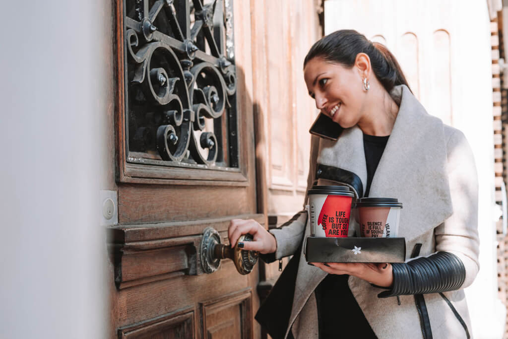 Woman holding two Coffee Island coffees.