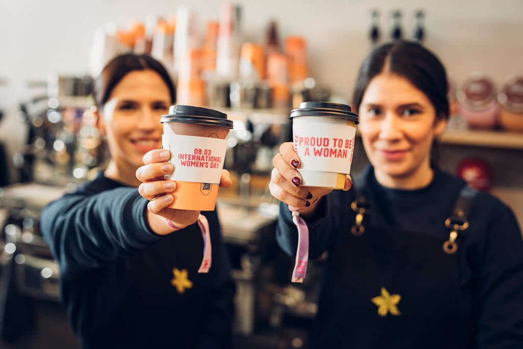 Baristas holding Coffee Island cups