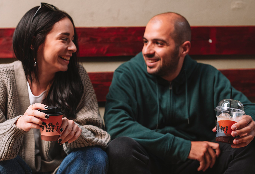 People smiling with coffee in their hand.