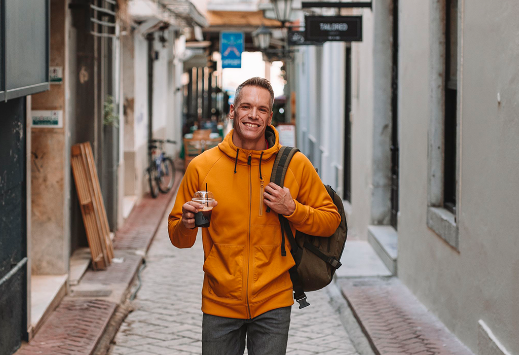 Person walks with coffee in his hand