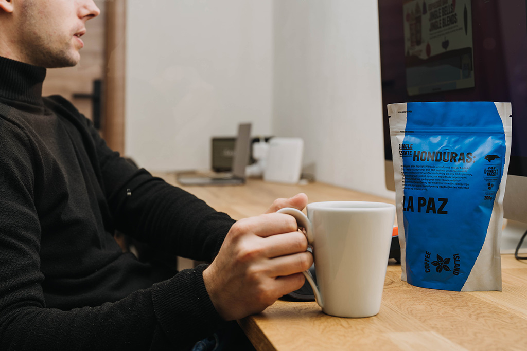 Man works with coffee in his hand