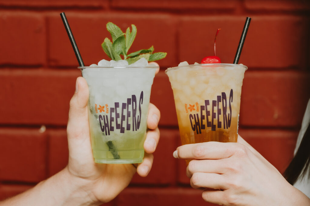 Two people are holding coffee island cup.